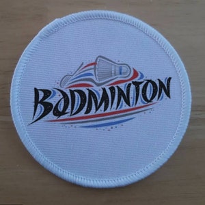 May include: White round fabric patch with a black and white badminton shuttlecock design and the word "BADMINTON" in black lettering.