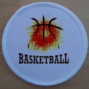 May include: White round patch with a black basketball graphic on a red and yellow splatter background. The text "BASKETBALL" is printed in black below the graphic.