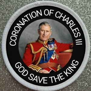 Peut inclure: Un patch circulaire noir et blanc avec le texte "Coronation of Charles III God Save The King" autour du bord. Une photo du roi Charles III dans ses robes de couronnement se trouve au centre du patch.