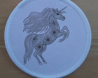 May include: A white round fabric patch with a black and white line drawing of a unicorn with a detailed mandala design. The unicorn is standing on its hind legs with its head turned to the side.