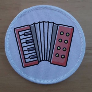 May include: A white round patch with a red and black accordion illustration. The accordion has a white keyboard and a red bellows with black lines.