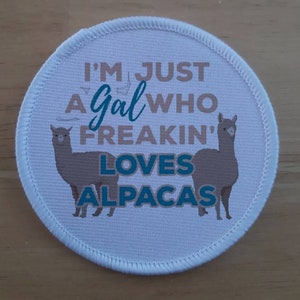 May include: White round patch with a brown alpaca on each side. The text on the patch reads "I'm just a gal who freakin' loves alpacas".