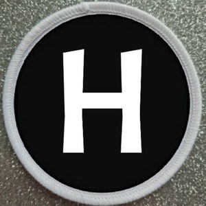 May include: White letter H on a black circle patch with a white border.