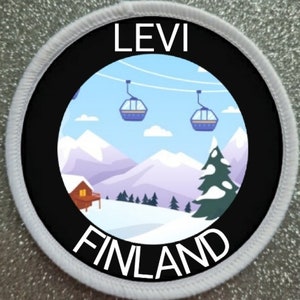 Könnte beinhalten: Runder Aufnäher mit schwarzem Rand und weißen Nähten. Er zeigt eine Winterlandschaft mit Skiliften, Bergen und einer Hütte. Der Text "LEVI" steht oben und "FINLAND" unten.