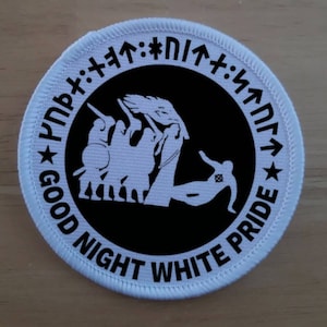 Puede incluir: Parche blanco bordado con un círculo negro que contiene una silueta blanca de un grupo de personas y una sola persona que cae. El texto "GOOD NIGHT WHITE PRIDE" está escrito alrededor del círculo en letras blancas. El texto "N17*" está escrito en letras blancas alrededor del círculo.
