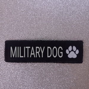 May include: Black patch with white text that reads "MILITARY DOG" and a white paw print.