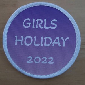 Könnte beinhalten: Ein runder Patch in Lila und Weiß mit dem Text "GIRLS HOLIDAY 2022" in Weiß.
