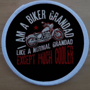 May include: A black and white round patch with a white border. The patch features a motorcycle with the text "I am a biker grandad like a normal grandad except much cooler".