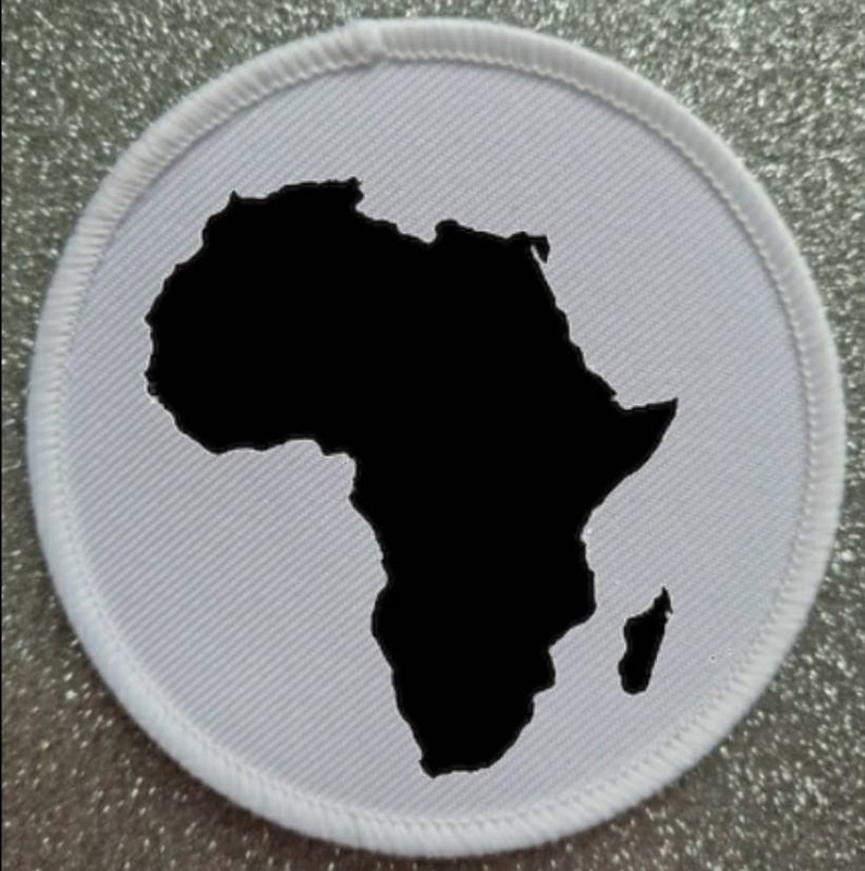 May include: White fabric patch with a black outline of the continent of Africa.