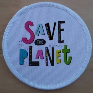 May include: A white round fabric patch with a colorful graphic that says "Save the Planet" in a playful font.