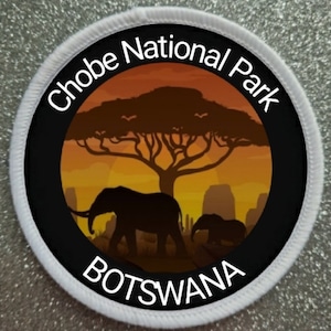 May include: A white circular patch with black text and a black and white image of an elephant and a tree. The text reads "Chobe National Park" and "BOTSWANA".