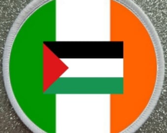 May include: A round white patch with a green, white, and orange background. The center of the patch features the Palestinian flag, which is black, white, red, and green.