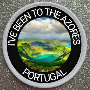 May include: White round patch with black text and a photo of a lake in a volcanic crater. The text reads "I've Been To The Azores Portugal".