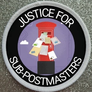 May include: A white and black circular patch with the text "Justice for Sub-Postmasters" around the edge. The center of the patch features a red British post box with several letters overflowing from the top.