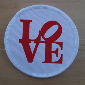May include: A white round fabric patch with a red "LOVE" graphic in a stylized font.