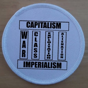 Könnte beinhalten: Ein weißer runder Patch mit schwarzem Text, der "CAPITALISM" über einem Diagramm mit den Wörtern "WAR", "CLASS", "EXPLOITATION" und "ALIENATION" in Spalten liest. Unter dem Diagramm steht das Wort "IMPERIALISM".