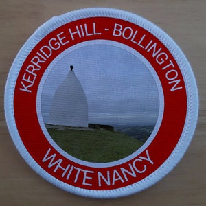 May include: A red and white round patch with the text "KERRIDGE HILL - BOLLINGTON WHITE NANCY" around the edge. The center of the patch features a photo of a white building with a pointed roof.
