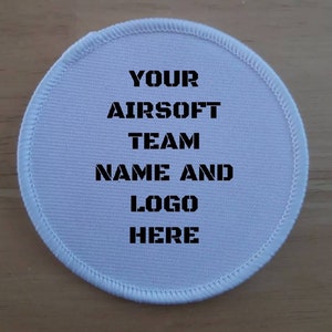 May include: White circular patch with black text that reads "YOUR AIRSOFT TEAM NAME AND LOGO HERE".