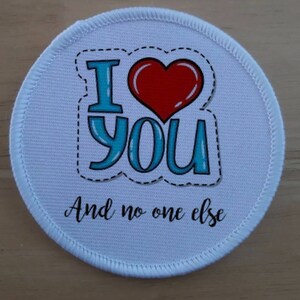 May include: White round fabric patch with a red heart and blue text that says "I love you and no one else".