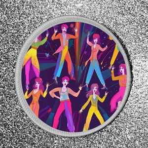 Könnte beinhalten: Runder Aufnäher mit einer lebendigen Illustration von Figuren in farbenfrohen Outfits im 70er-Jahre-Stil, vor einem dunkelvioletten Hintergrund mit Regenbogen- und Sternen-Elementen. Der Aufnäher hat einen weißen Rand.
