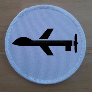 Op de afbeelding: Witte ronde patch met een zwart silhouet van een drone met een propeller aan de achterkant.