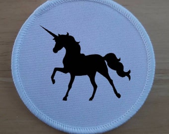 May include: White round fabric patch with a black silhouette of a unicorn with a horn.