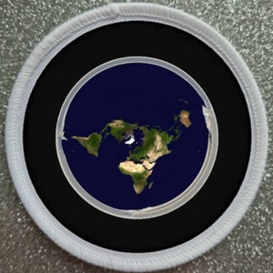 May include: A white circular patch with a black border and a blue and green image of the Earth inside. The image shows the Earth as a flat disc with the continents arranged in a circle.