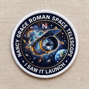 May include: A circular embroidered patch featuring the Nancy Grace Roman Space Telescope in orbit. The design includes a deep space nebula background, the Earth, the NASA logo, and the text NANCY GRACE ROMAN SPACE TELESCOPE and I SAW IT LAUNCH.