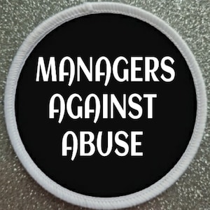 May include: A black and white round patch with the text "MANAGERS AGAINST ABUSE" in white.