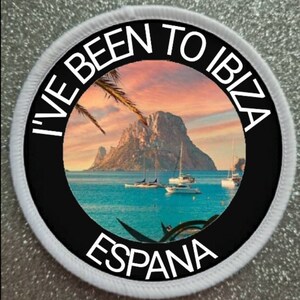 May include: A white round patch with black text that says "I've Been To Ibiza, Espana". The patch has a circular image of a beach scene with a rocky island, palm trees, and sailboats in the distance.