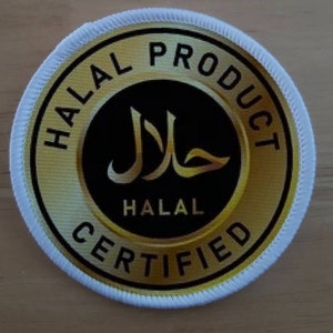Puede incluir: Una pegatina redonda dorada y blanca con el texto "HALAL PRODUCT CERTIFIED" alrededor del borde. El centro de la pegatina tiene un fondo negro con la palabra árabe para "Halal" en letras doradas y la palabra "HALAL" en inglés debajo.