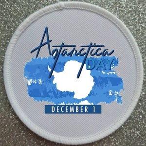 May include: White round patch with blue and white graphic of Antarctica and the text "Antarctica Day December 1".