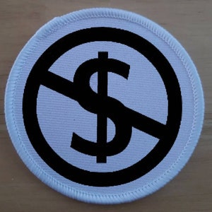 May include: A white round patch with a black circle and a diagonal line through a black dollar sign. The patch has a white stitched border.