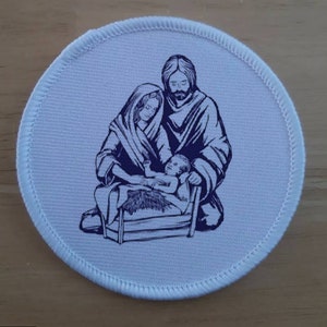 May include: A white round patch with a blue image of the Holy Family. Mary, Joseph, and baby Jesus are depicted in a simple, line-art style.