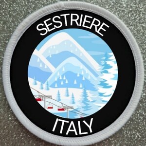 Op de afbeelding: Een wit-zwarte ronde patch met een witte rand. Het midden van de patch is zwart met een witte cirkel erin. De witte cirkel toont een cartoon-illustratie van een besneeuwde bergketen met een skilift. De tekst "SESTRIERE ITALY" is in wit op een zwarte achtergrond gedrukt.