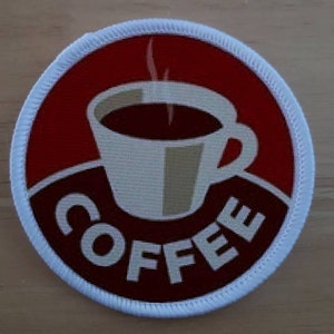 以下が含まれることがあります： 赤い背景に白いコーヒーカップが置かれ、白い文字で「COFFEE」と書かれています。カップには茶色の取っ手が付いており、蒸気が上がっています。