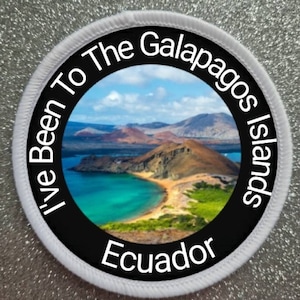 May include: A white round patch with black text that reads "I've Been To The Galapagos Islands Ecuador". The patch has a photo of a beach and mountains in the center.