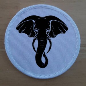 May include: White round patch with a black silhouette of an elephant's head and trunk.