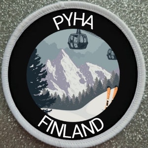 Puede incluir: Parche redondo con borde negro y costuras blancas. Presenta un paisaje invernal con montañas, árboles y teleféricos. El texto "PYHA" está en la parte superior y "FINLAND" en la inferior, en blanco.