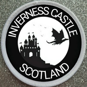 May include: Black and white round patch with the text "Inverness Castle Scotland" around the edge. The center of the patch features a silhouette of a castle and a dragon flying away from it.