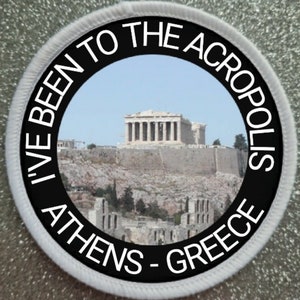 Peut inclure: Un écusson rond blanc avec du texte noir qui dit "I've Been To The Acropolis Athens - Greece". L'écusson présente une photo de l'Acropole à Athènes, en Grèce.