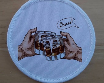 May include: White round fabric patch with a graphic of three glasses of whiskey being clinked together with the text "CHEERS!" in a speech bubble.
