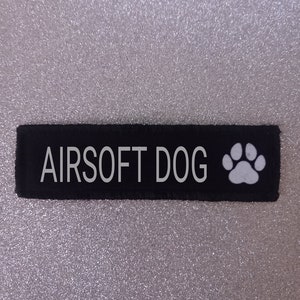 May include: Black patch with white text that reads "AIRSOFT DOG" and a white paw print.