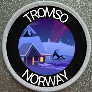 May include: A white round patch with black text that reads "Tromso Norway" and a black circle in the center with a colorful image of a snowy house with a purple aurora borealis in the background.