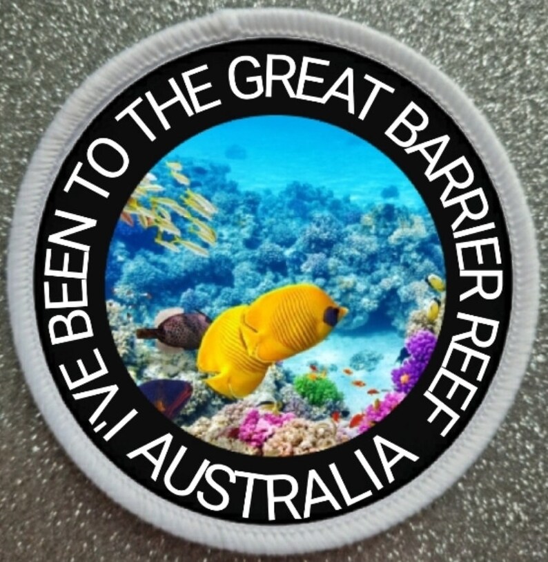 May include: A white round patch with black text that reads "I've Been To The Great Barrier Reef Australia". The center of the patch features a colorful underwater scene with coral, fish, and blue water.