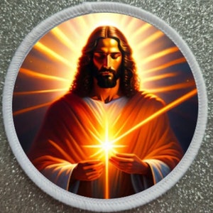 May include: Round patch featuring a portrait of Jesus with long brown hair and a beard, radiating light. The image is set against a backdrop of golden rays, with a white border.