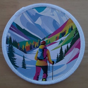 May include: A colourful, abstract illustration of a skier in a yellow jacket and pink trousers, skiing down a mountain with a blue rucksack. The background features a snowy mountain range with colourful trees and a blue sky.