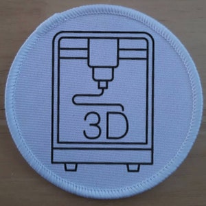 Op de afbeelding: Ronde witte stoffen patch met een zwarte omtrek van een 3D-printer en de tekst "3D" eronder.