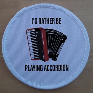 May include: White round patch with black text that reads "I'd rather be playing accordion". A black and white accordion is pictured in the center of the patch.