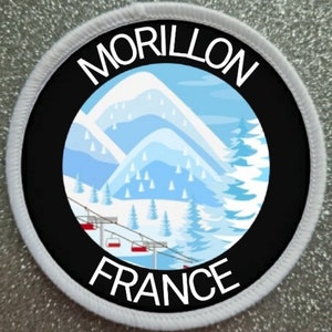 May include: A white and black circular patch with a white border. The centre of the patch is black with a white mountain scene and a ski lift. The text "MORILLON FRANCE" is written in white around the mountain scene.